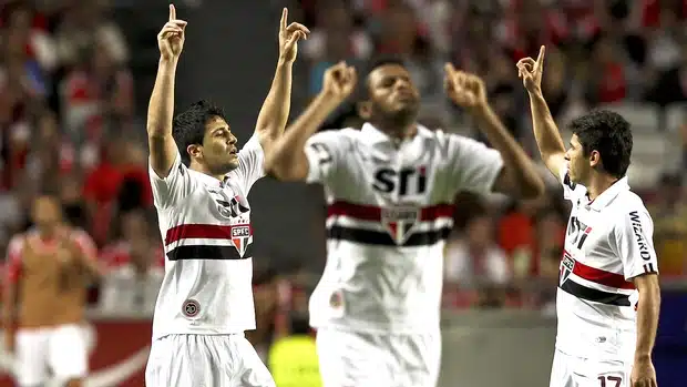 Jogadores do São Paulo comemoram apontando para o céu contra o Benfica